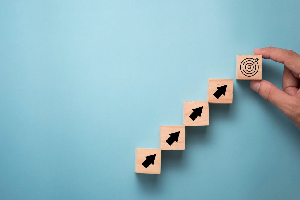 hand-putting-virtual-target-board-arrow-which-print-screen-wooden-cube-business-achievement-goal-objective-target-concept-1024x682-1.jpg